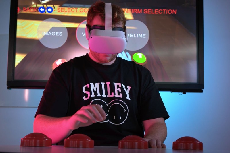 A person wearing a VR headset pressing buttons with virtual buttons appearing on a screen behind