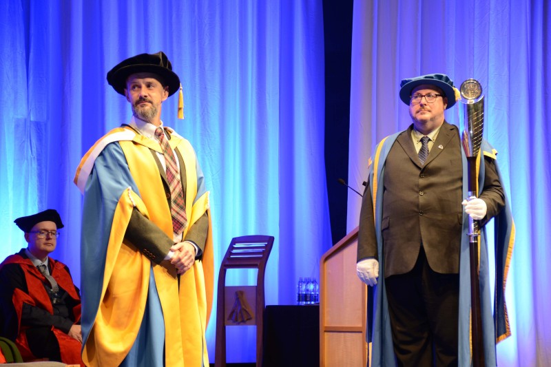 Max Murdo standing on the stage in his ceremonial graduation robes